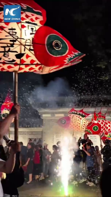 Cina: parata di lanterne a forma di pesce in un antico villaggio