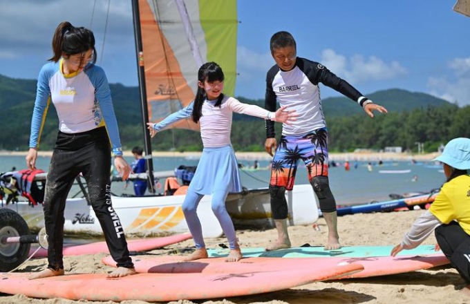 Cina: Hainan, turisti imparano a surfare a Sanya (1)